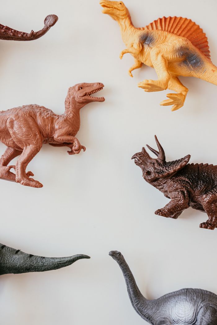 A vibrant assortment of dinosaur toy models against a white background.